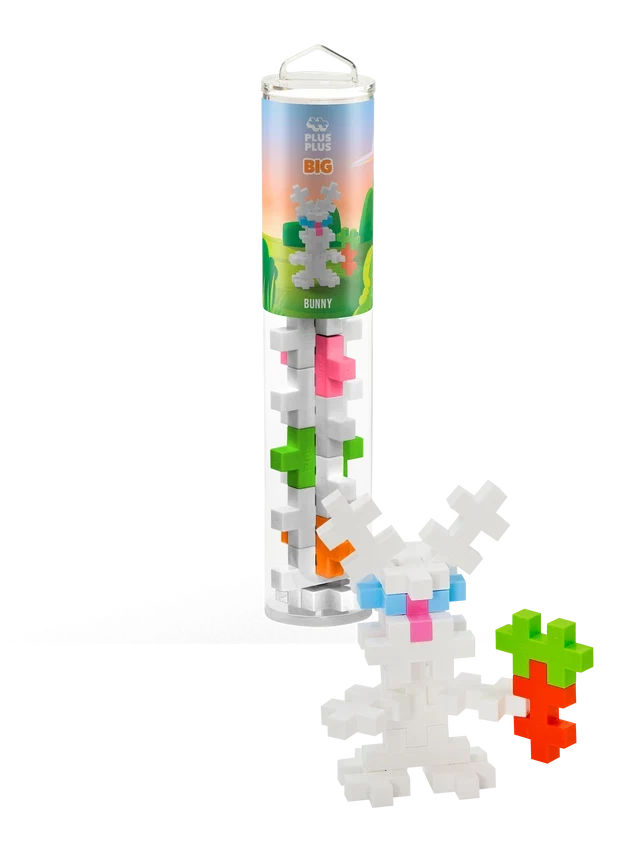 Interlocking plus-shaped building blocks in a tube next to a built white bunny figure holding a block carrot.