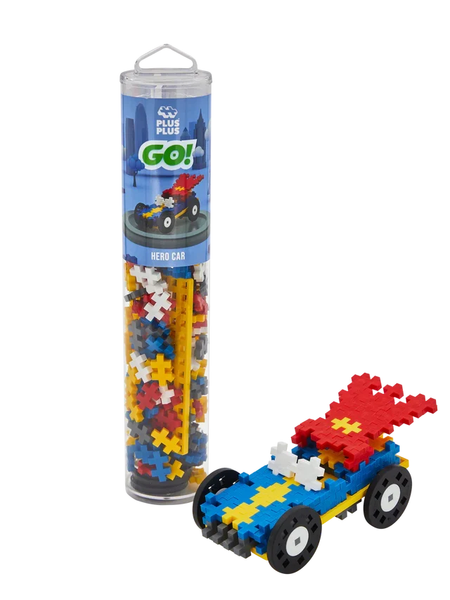 Colorful plus-shaped blocks in a tube next to a built blue race car with red wings and black wheels.
