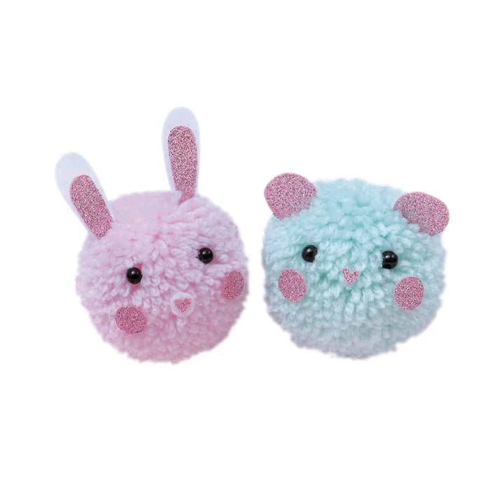 Fuzzy pink bunny and light blue bear pom-poms with black bead eyes and pink glittery ears, cheeks, and noses.