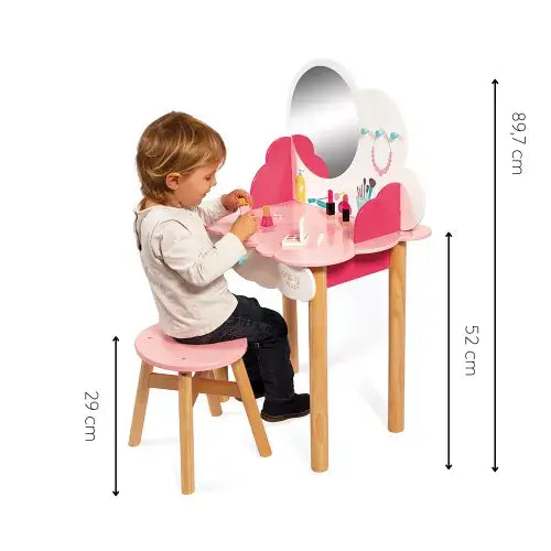 Child sits at a pink cloud-shaped wooden vanity with an oval mirror, matching stool, and accessories. Dimensions included.