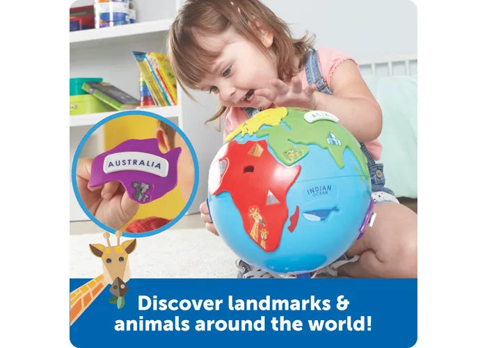 Toddler playing with a blue 3D puzzle globe featuring colorful continent pieces with animals like a koala and giraffe.