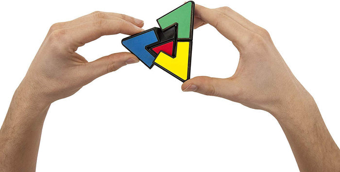 Hands holding a black triangular puzzle with blue, green, and yellow segments and a small red center.