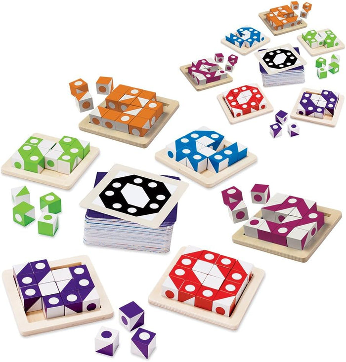 Multiple sets of colorful patterned wooden cubes in square trays alongside stacks of challenge cards.