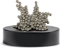 Shiny silver magnetic balls stacked in an abstract, spiky cluster on a matte black circular base.
