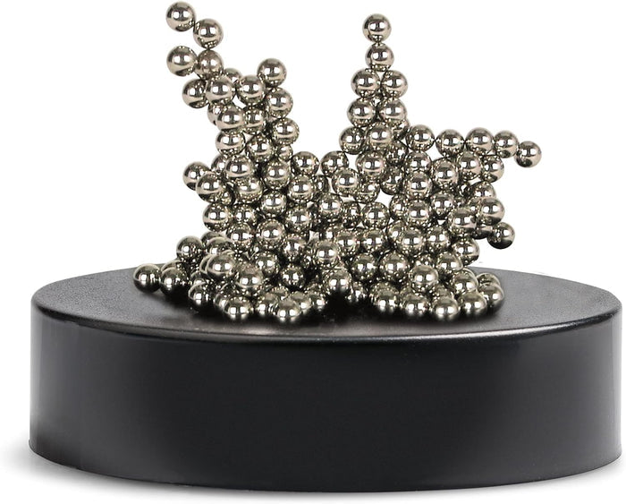 Shiny silver magnetic balls stacked in an abstract, spiky cluster on a matte black circular base.