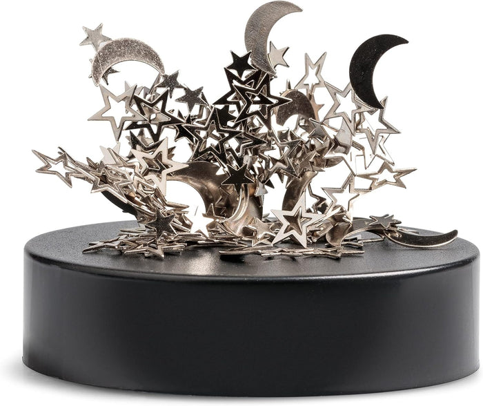 Magnetic desk sculpture with silver metallic stars and crescent moons piled on a round black base.