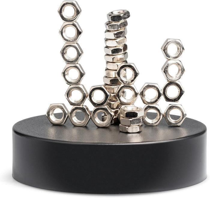Shiny silver hexagonal nuts stacked in gravity-defying towers on a black circular magnetic base.