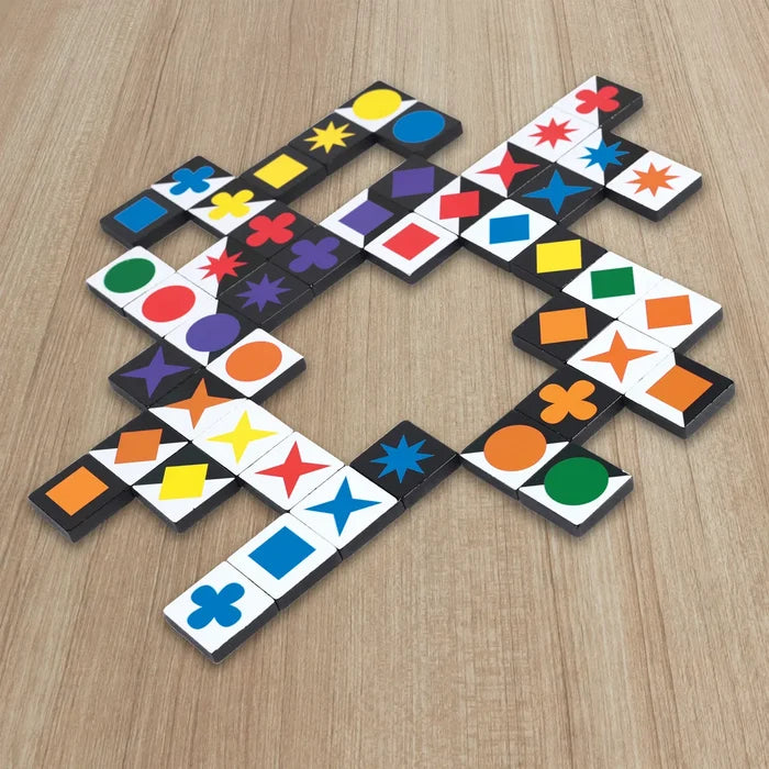 Black and white square tiles with colorful shapes like stars and circles arranged on a light wood surface.