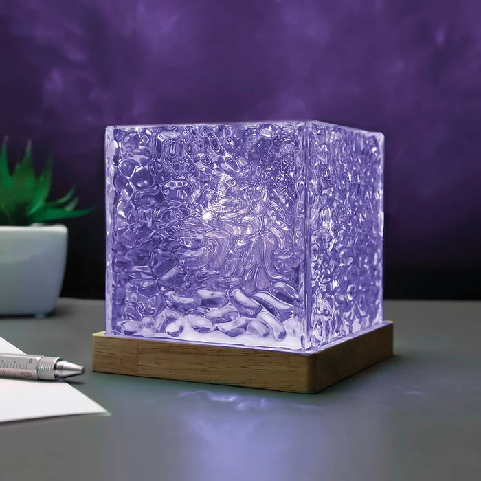 Glowing purple cube lamp with a rippled, water-like texture on a square wooden base.