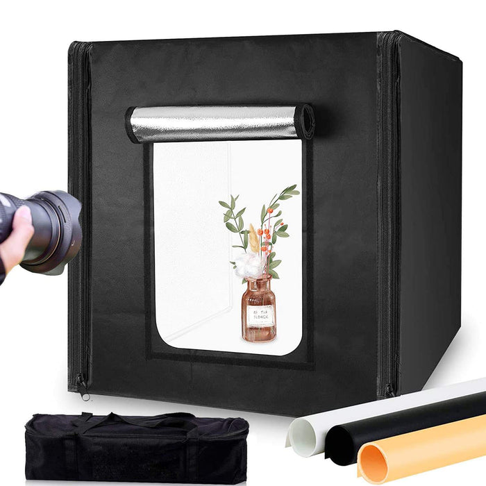 A portable LED light box photo studio with a black exterior and white interior, equipped with a window for shooting, surrounded by various accessories such as a carry bag, metal rods, and a tripod.