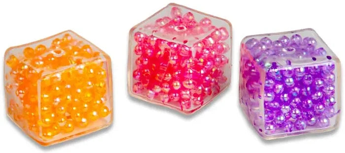 Three clear plastic cubes filled with tiny, shiny beads in orange, bright pink, and purple.