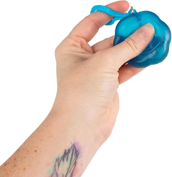 Hand squeezing a blue flower-shaped translucent squishy toy with an attached blue plastic clip.