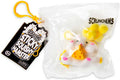 White squishy hamster toy holding cheese in a clear bag with yellow pom-poms, a black tag, and a yellow clip.