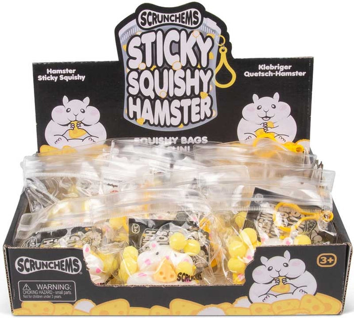 Black display box of white hamster squishy toys in clear bags with yellow clips. Toys feature small cheese wedges.