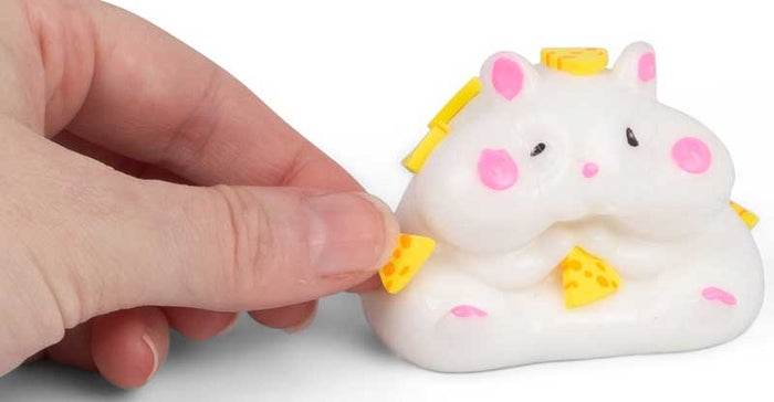 White squishy hamster toy with pink accents and yellow cheese wedges being touched by a hand.
