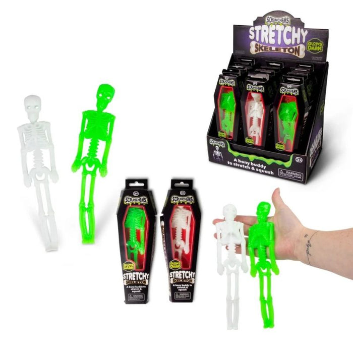 Neon green and white stretchy toy skeletons in coffin boxes, a store display stand, and held in a hand for scale.