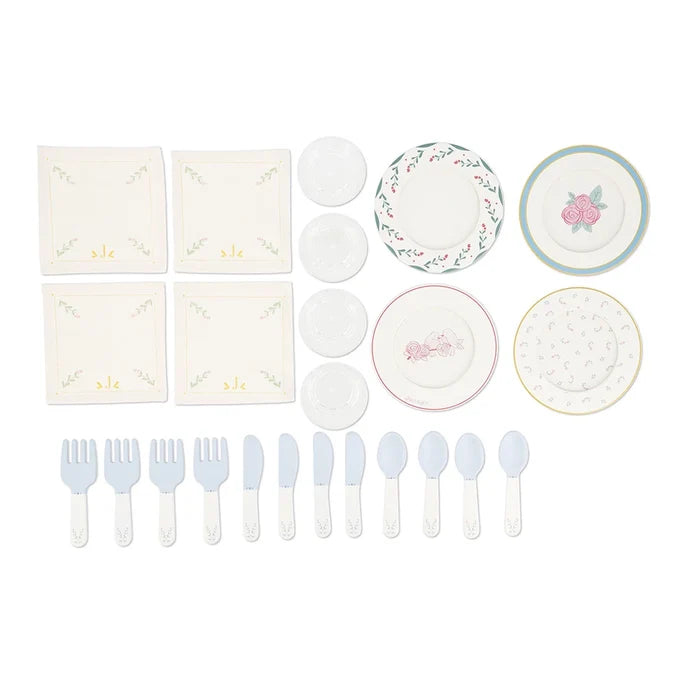 Toy dinette set with floral plates, saucers, white napkins, and light blue cutlery on a plain white background.