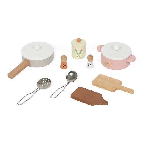 Pastel wooden toy cookware set with pink pot, grey pan, metal ladle, slotted spoon, shakers, and cutting boards.