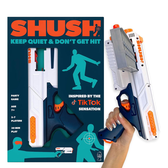 A white and navy blue SHUSH toy blaster with a vertical magazine held in a hand next to its teal and orange packaging.