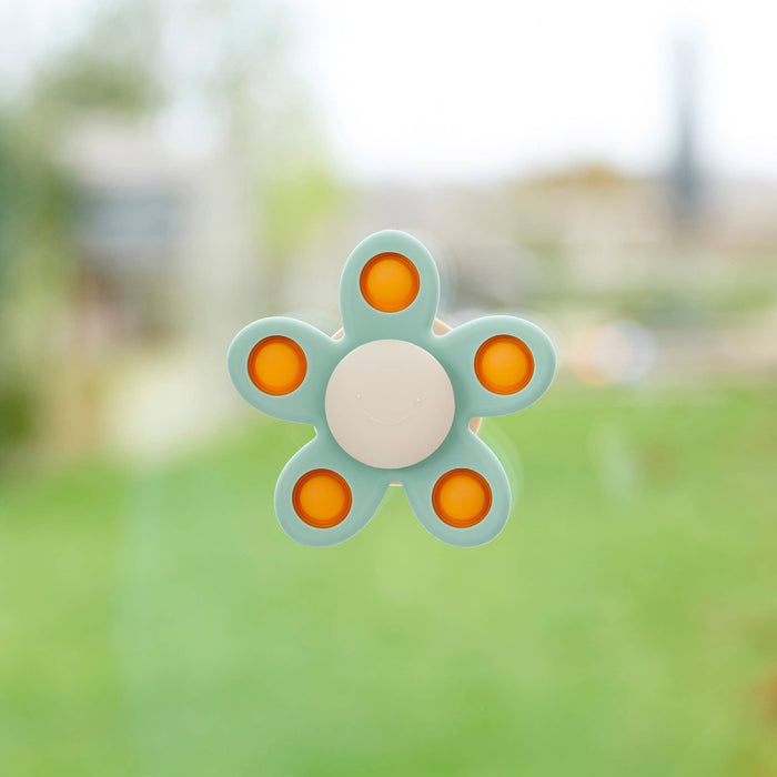 Teal five-petal flower spinner with five orange popping buttons and a cream-colored smiley face center.