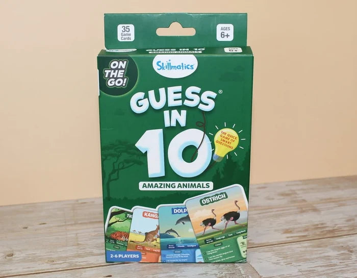 Green Skillmatics Guess in 10 game box with animal illustrations and a yellow lightbulb graphic on a wood surface.