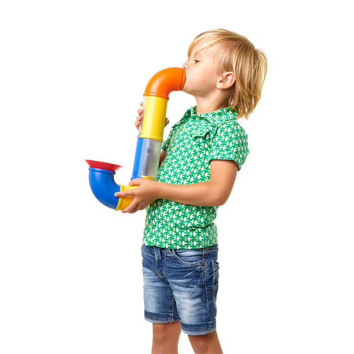 Child holding a curved toy pipe made from bright orange, yellow, and blue magnetic pieces on a white background.