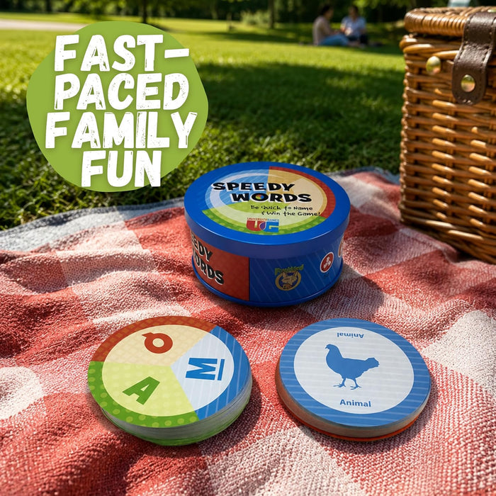 Round blue tin and circular game cards on a red checkered blanket. Cards show colored letters and an animal silhouette.