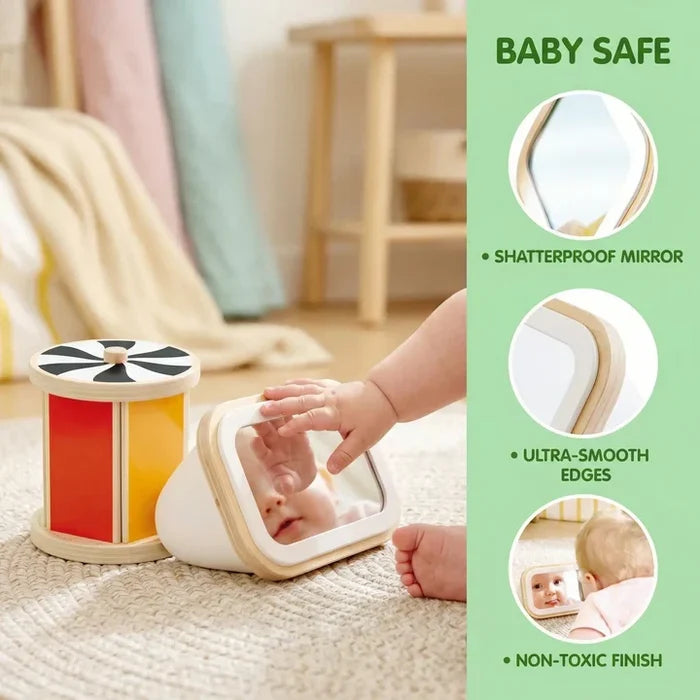 Baby playing with a red and yellow wooden drum and a white triangular mirror toy featuring smooth, rounded edges.