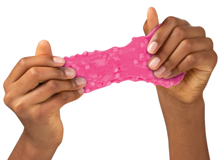 Hands stretching bright pink, textured putty with small bumps on a white background.
