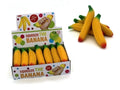 Yellow foam bananas with green stems and red tips in a colorful display box next to a pile of loose toy bananas.