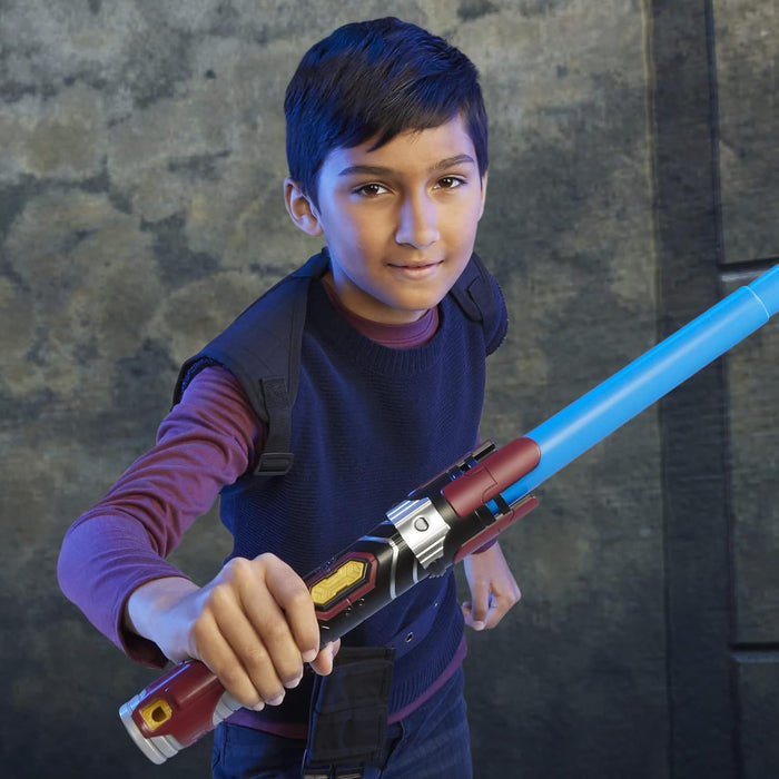 Young boy holding a blue toy lightsaber with a red, black, and silver hilt against a dark background.