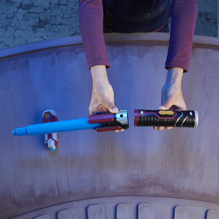 Hands connecting a blue lightsaber blade to a black and maroon hilt as part of a modular Star Wars toy set.