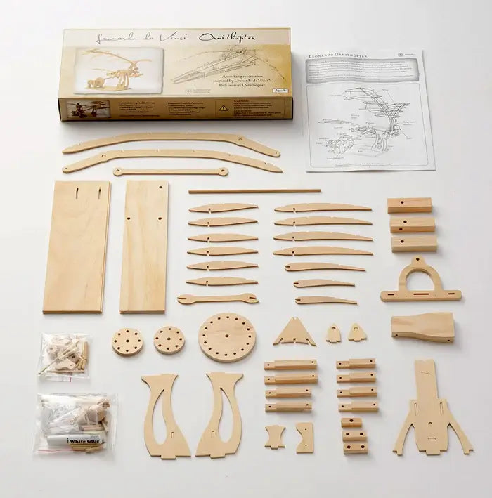 Light wood laser-cut model pieces, gears, and wings neatly arranged with an instruction manual and illustrated box.