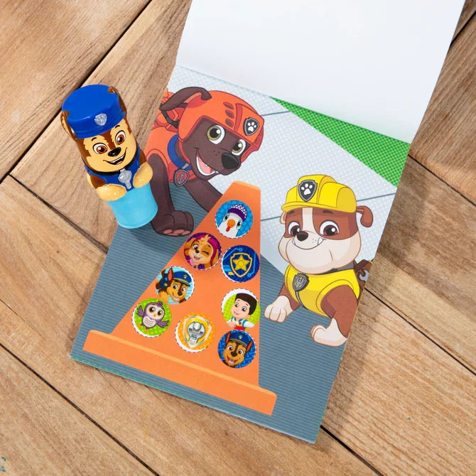 Blue PAW Patrol Chase sticker stamper toy and activity pad featuring Zuma and Rubble on a wooden surface.