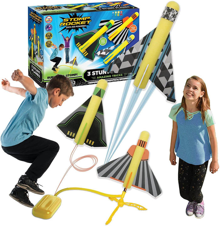 Packaging and kids playing with yellow foam stunt planes launched by a boy jumping on a yellow stomp pad.