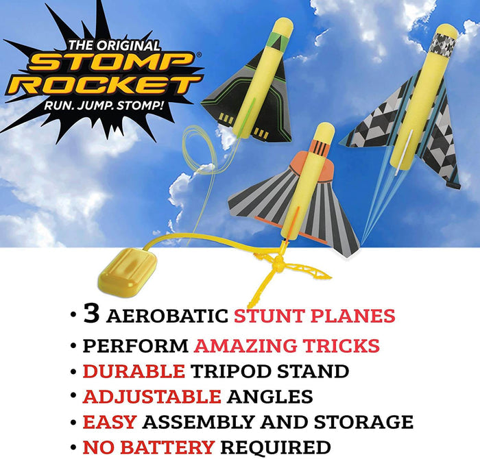 Three yellow foam stunt planes with patterned wings fly above a yellow stomp pad and launch stand in a blue sky.