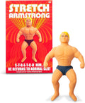 Muscular blond action figure in dark trunks next to its red and yellow retro-style packaging box.