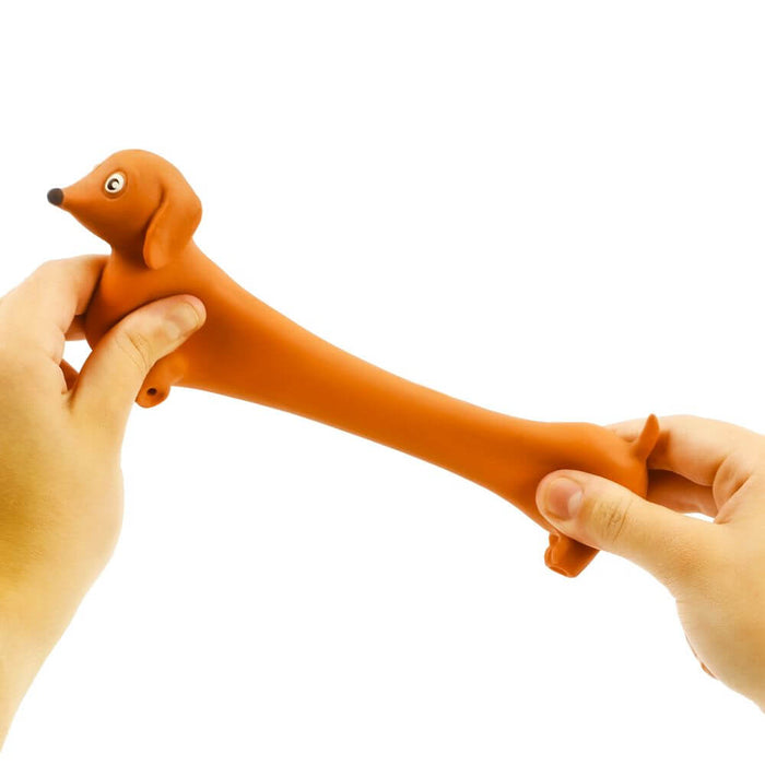 Hands pulling and stretching a flexible brown dachshund toy with floppy ears and short legs.