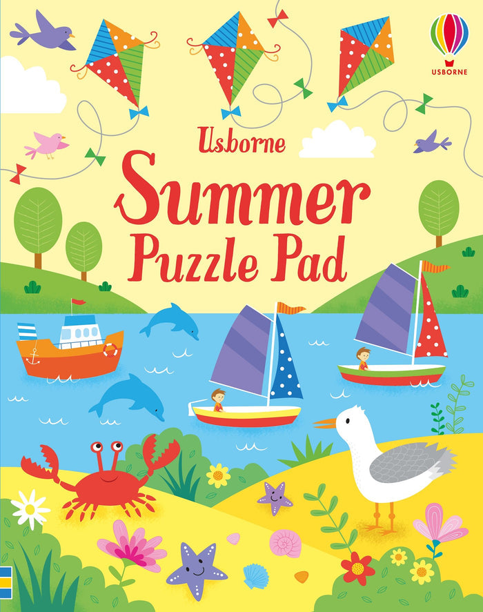 Bright activity book cover featuring a summer beach scene with kites, sailboats, dolphins, a red crab, and a seagull.
