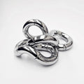 Shiny silver kinetic sculpture of interconnected, rotating curved metal segments twisted into an abstract shape.