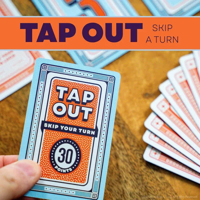 Hand holding a light blue card with an orange center featuring Tap Out, Skip Your Turn, and 30 Points text.