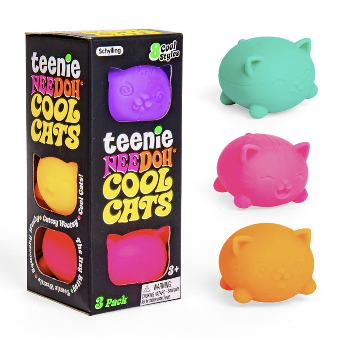 Three cat-shaped squishy toys in mint, pink, and orange next to a black box displaying more colorful toys through cutouts.