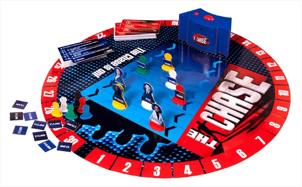 The Chase board game with circular board, electronic buzzer, character standees, question cards, and currency tokens.