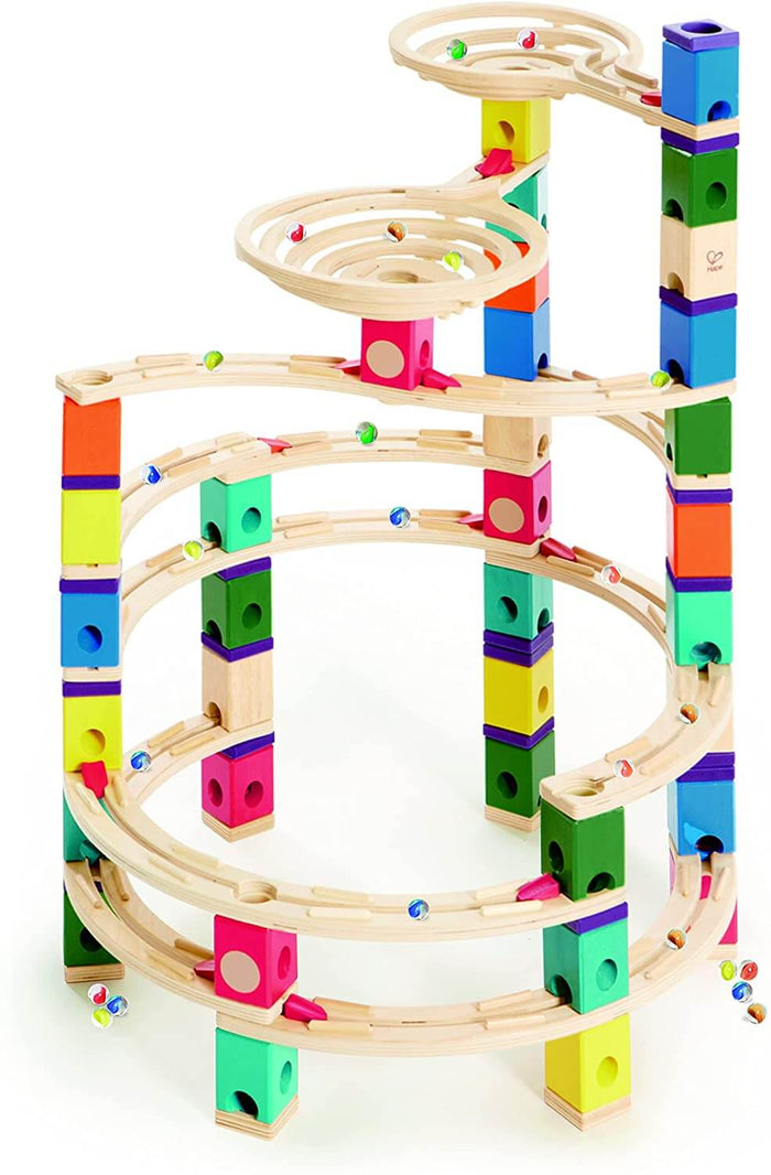 Colorful wooden marble run tower with spiral tracks, bright square blocks, and glass marbles on a white backdrop.