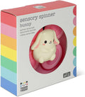 White bunny toy in a pink spinning frame, inside a white box with rainbow stripes and Tiger Tribe branding.