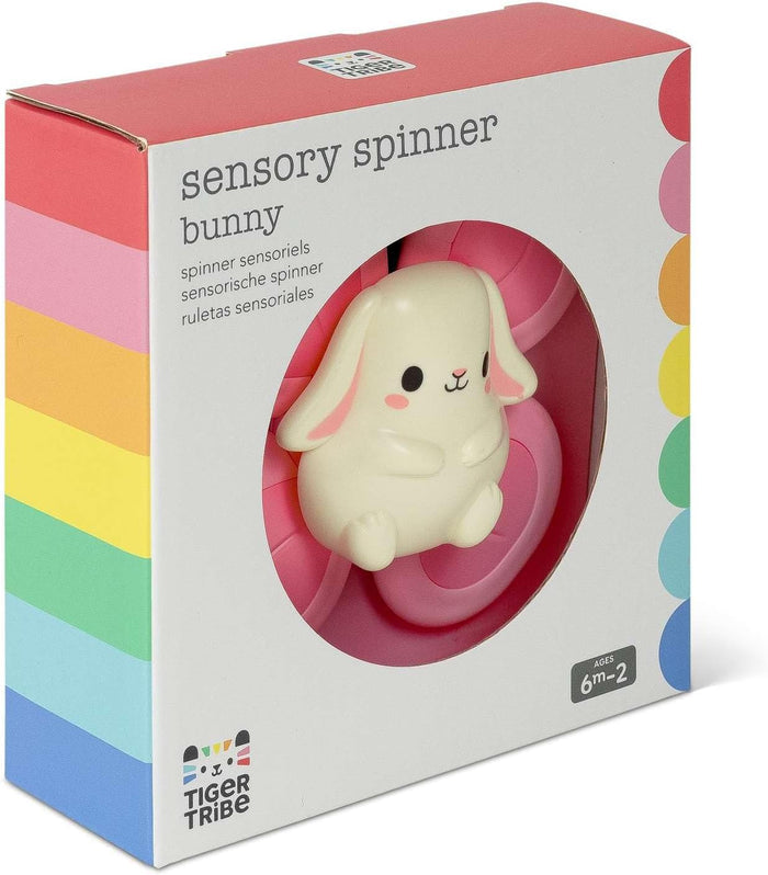 White bunny toy in a pink spinning frame, inside a white box with rainbow stripes and Tiger Tribe branding.