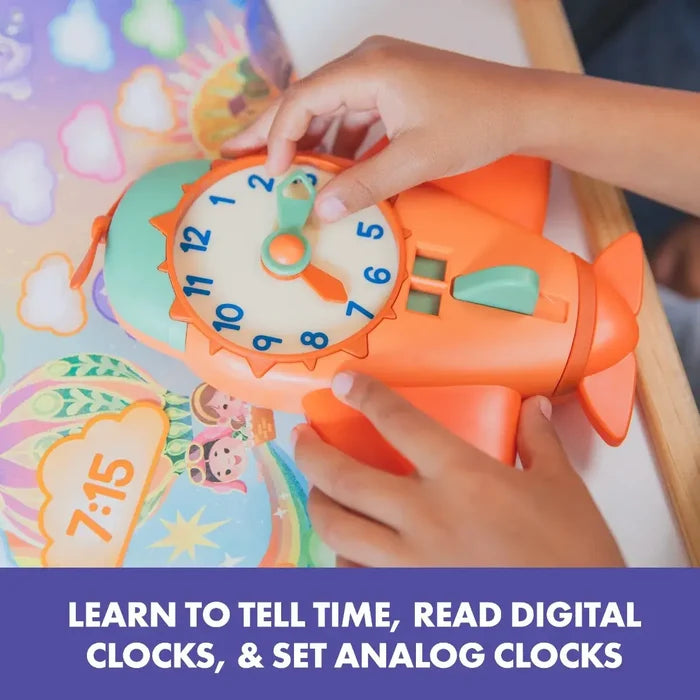 Child's hands setting an orange airplane-shaped toy clock with blue numbers and green hands.