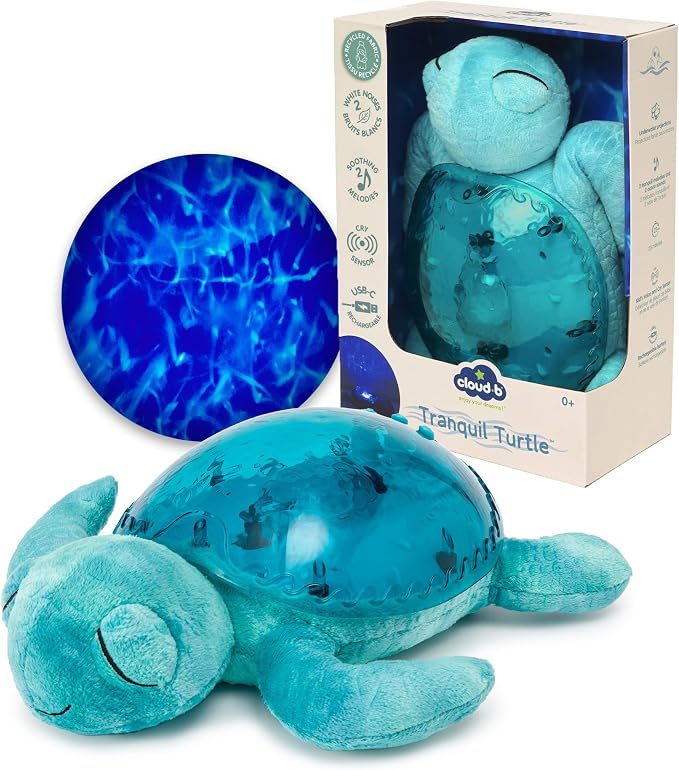 A plush aqua-blue sea turtle with a glowing translucent shell next to its box showing underwater light projections.