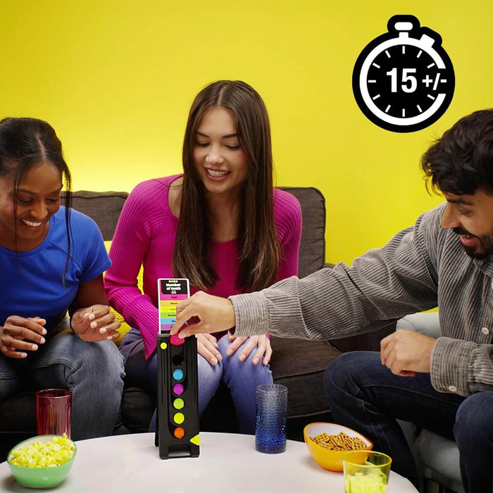 Three people playing a trivia game by dropping colorful discs into a vertical black tower on a table with snacks.