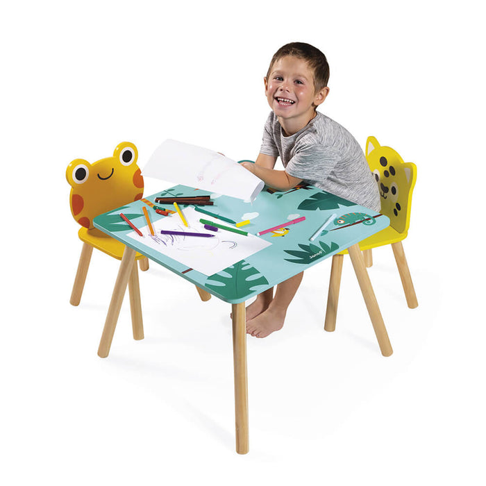 Blue tropical table with yellow frog and leopard chairs. A boy sits at the table drawing with markers.